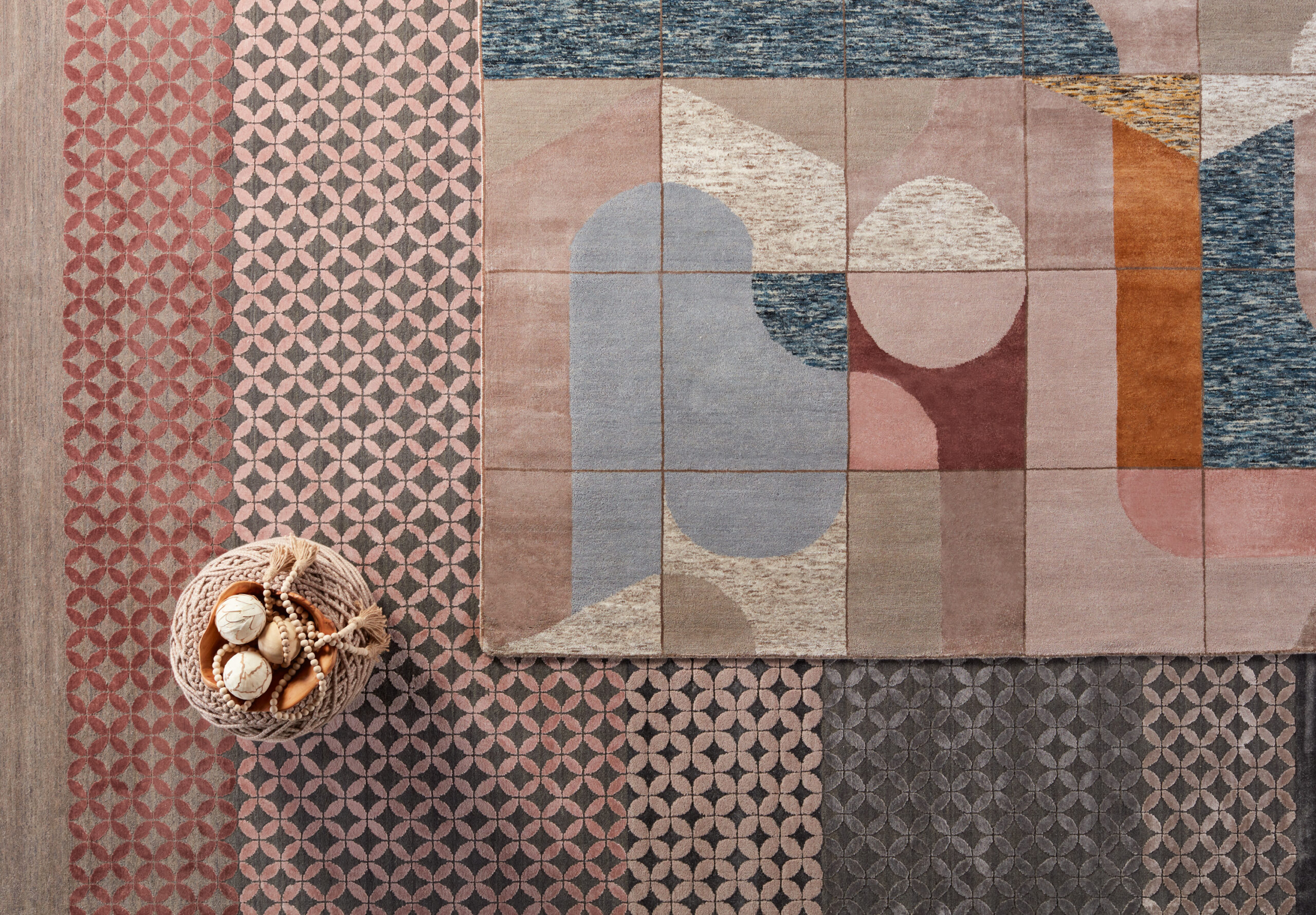 Blue, cream, pink, and gray patterns rugs layered on top of each other