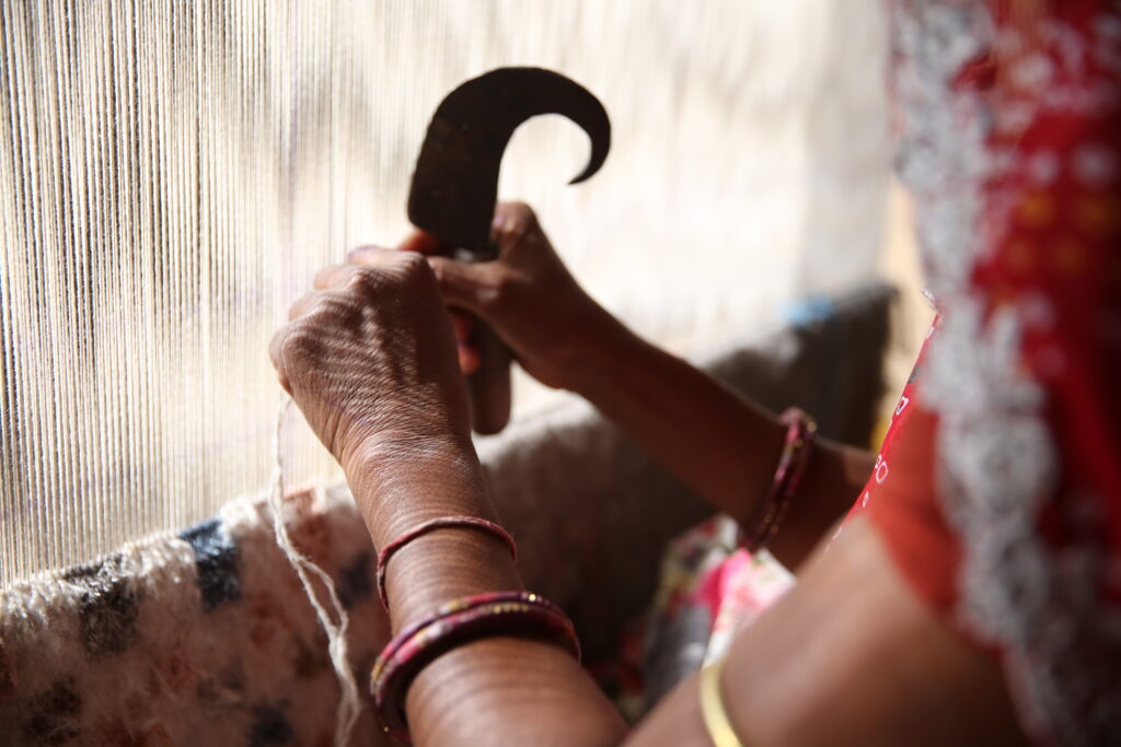 an artisan makes a hand-knotted rug