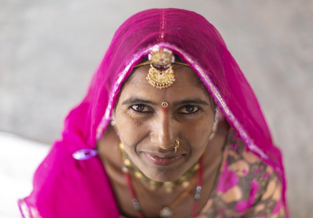 an artisan in a hot pink sari and veil