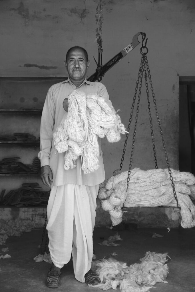 a man weighs spun wool
