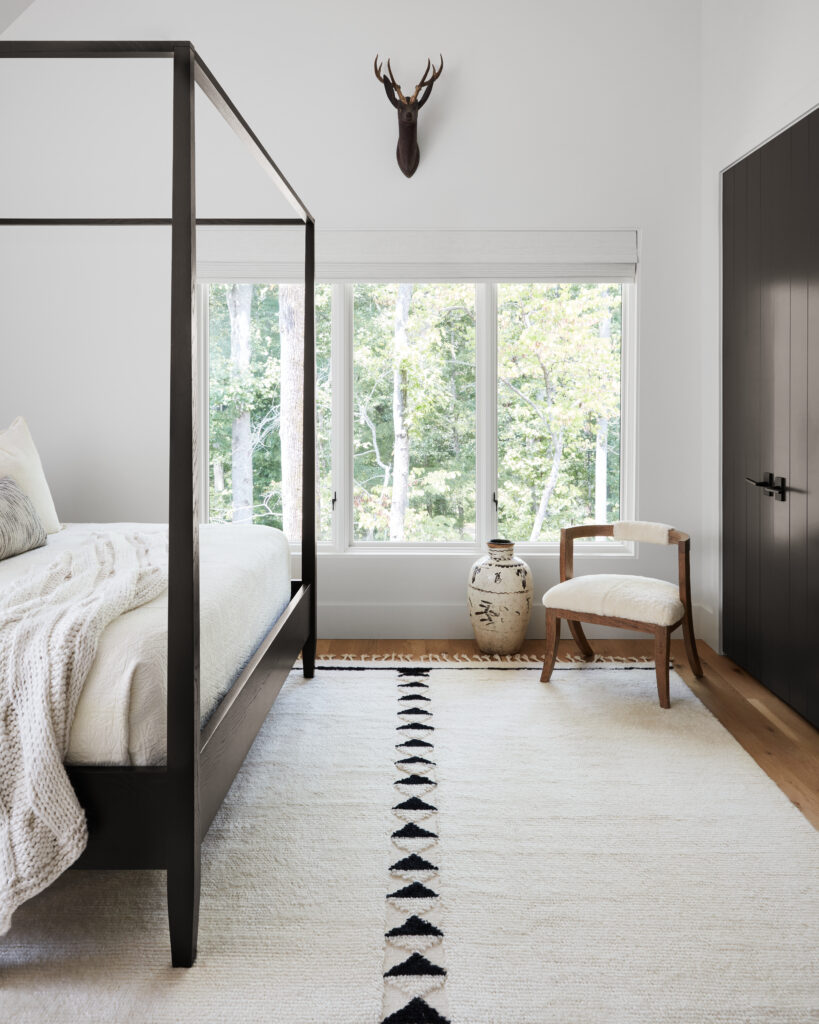 A black-and-white bedroom with a white rug and linear triangular black pattern