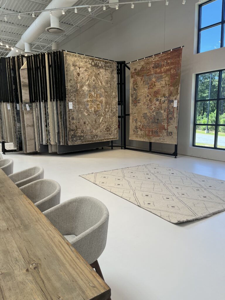 rug racks in front of a wooden conference table with gray chairs