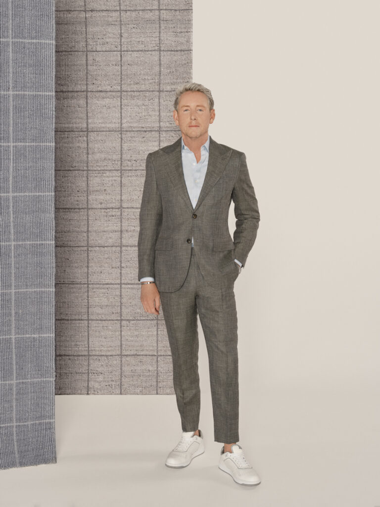 Interior designer Barclay Butera stands in front of two gray checkered rugs