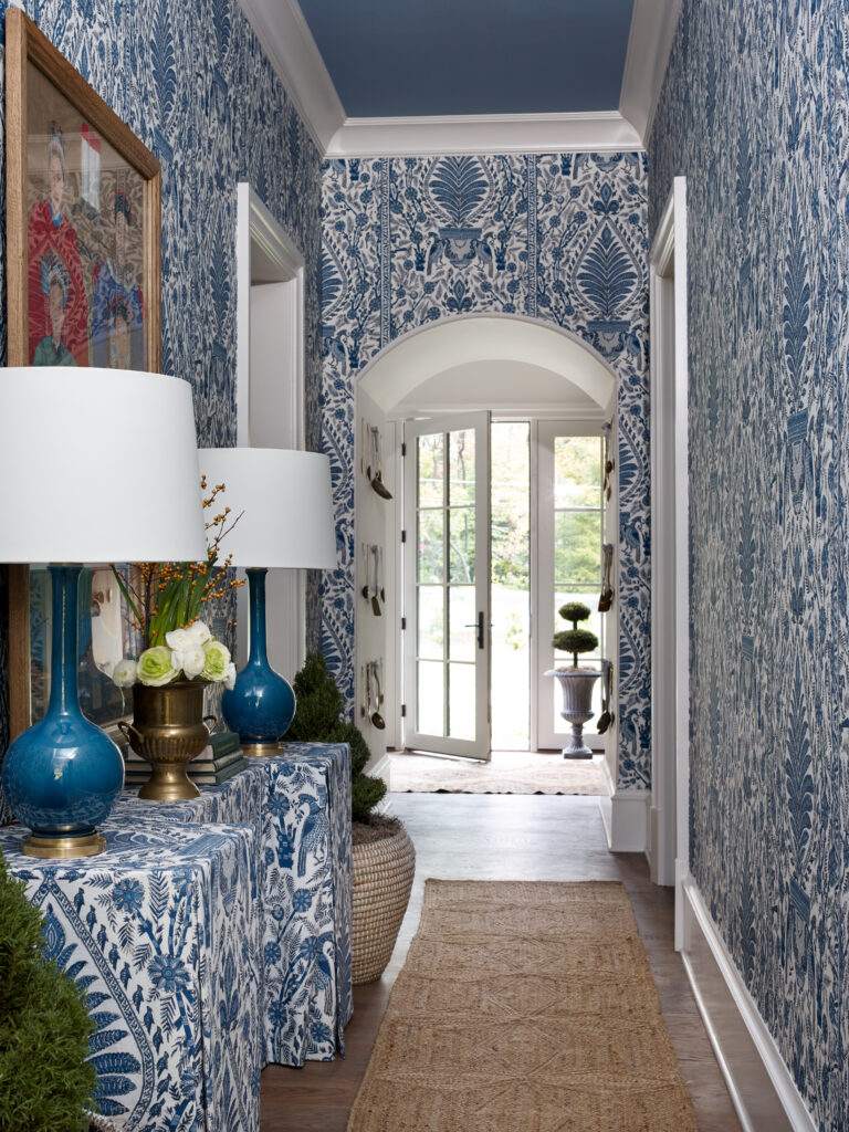 A hallway and blue and white toile wallpaper and furnishings